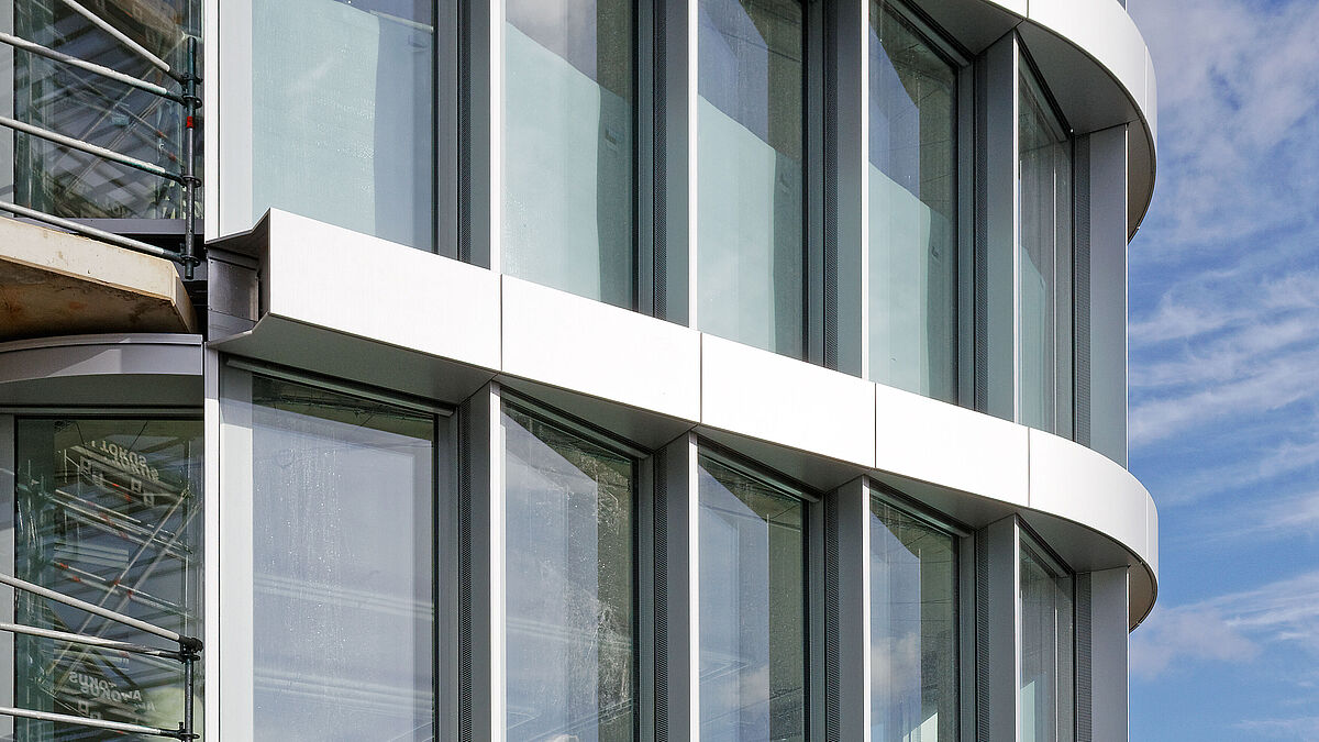 Photo: Tom ReindelAlors que les faces frontales ont été dotées d’éléments en verre à hauteur d’étage, les faces latérales en aluminium fermées intègrent un clapet de 1,40 x 0,20 m.