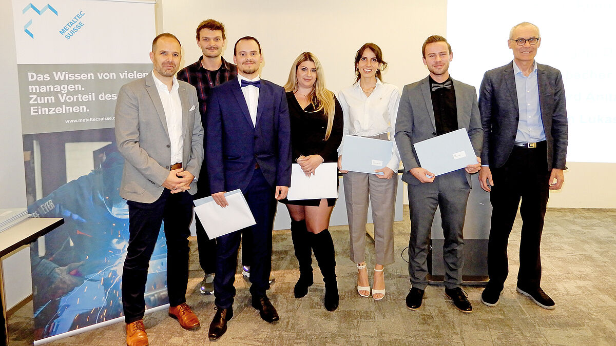 Ein kleiner Teil der frisch diplomierten Metallbaukonstrukteur*innen beim gruppenweise abgehaltenen Fototermin, flankiert von Stephan Gutknecht (ganz links) und Artho Marquart, Vizepräsident AM Suisse und Präsident Metaltec Suisse (ganz rechts).