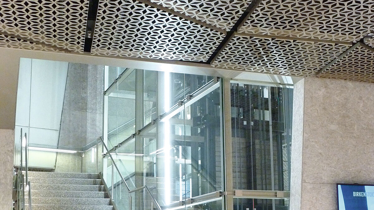 L’escalier en acier en cône, toujours plus étroit à mesure que l’on monte, est pourvu de garde-corps en verre. Des LED intégrées à la main courante en acier inoxydable éclairent la zone de passage.