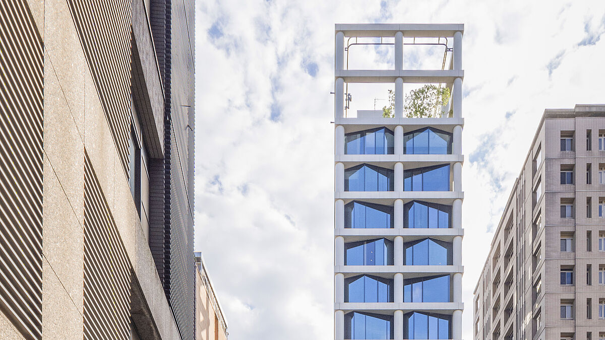 Treize étages dotés de façades en verre carrées. Alternance des formes convexes et concaves (derrière la colonne).