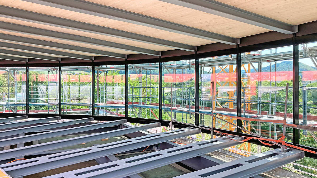 La structure porteuse secondaire rayonne en éventail depuis le centre. Certaines poutres en saillie sont soudées pour former des ensembles de poutres jumelées. Photo : Bäumlin+John AG Miró Messerli