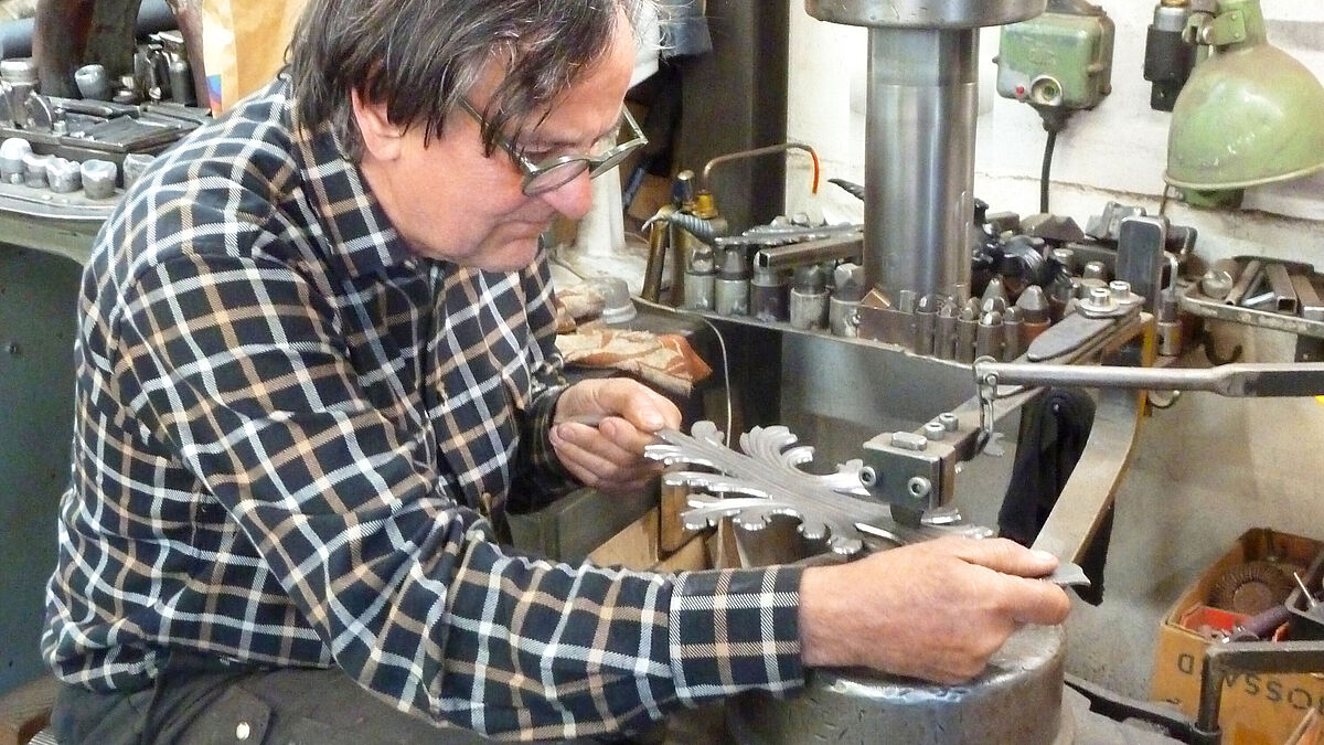 Moritz Häberling (70 ans), lors de l’une des premières étapes de la réalisation des ornements : les estampages au marteau pneumatique, le long des marquages laser.