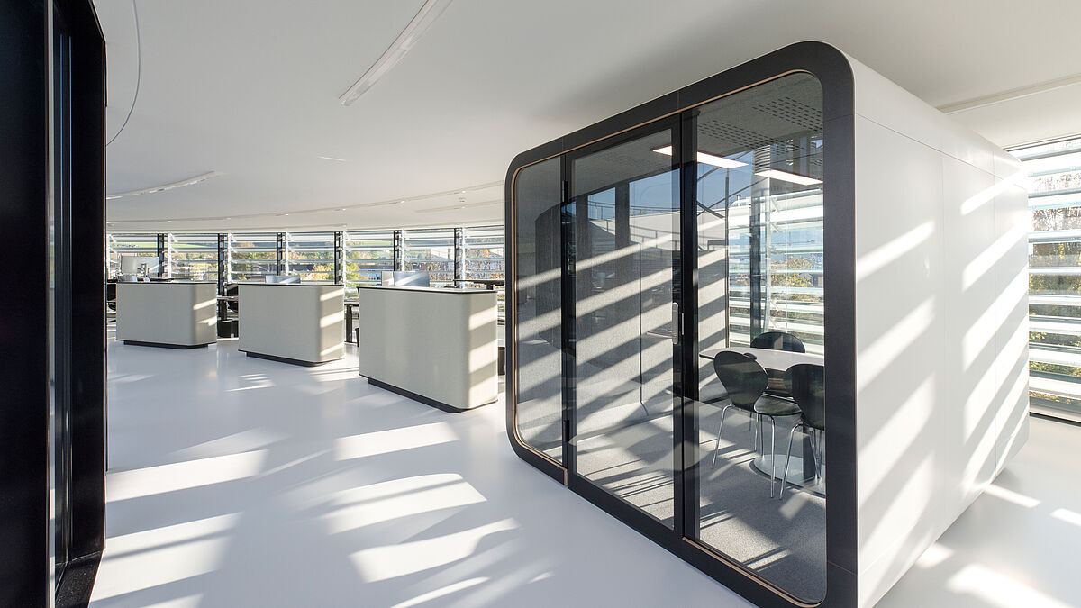 Six cabines de réunion insonorisées et disposées librement dans l’espace assurent à la fois discrétion et calme. Elles permettent par ailleurs de structurer les locaux. Photo : Zuzana Oplatek