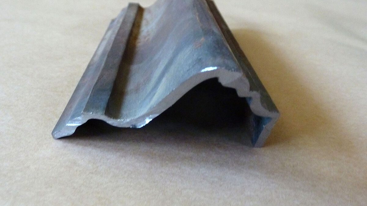 Das Stichbogenprofil des Tors: aus einem Flachstahl gesenkgeschmiedet und anschliessend unter Wärmeeinfluss im Radius gebogen. Bild: Redaktion