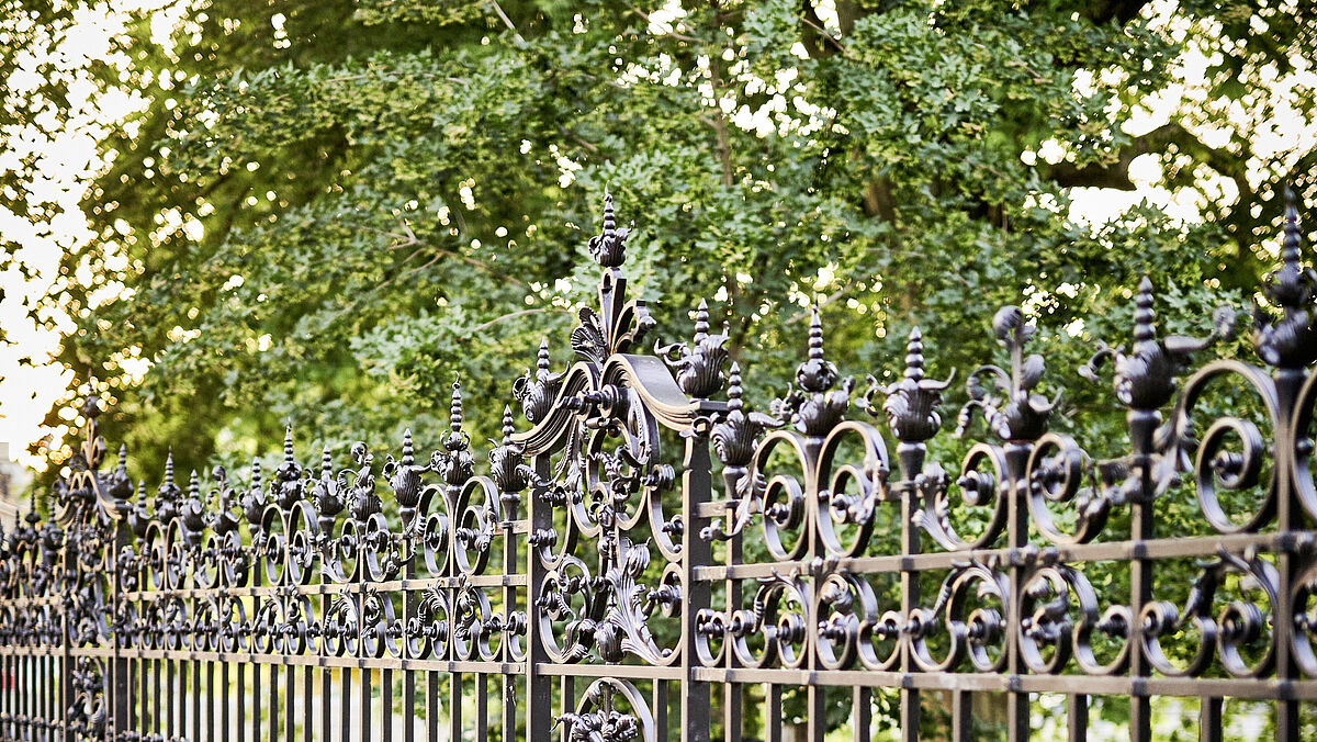 La clôture d’environ 60 m de long a été restaurée selon le même style de finition que la porte. Traitement de surface : galvanisé à chaud, poli à la main et couche de fond et de finition bicomposant.
