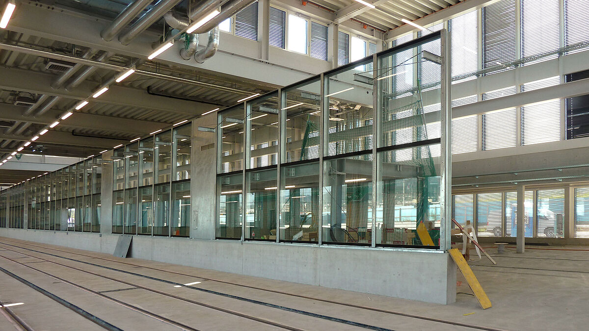 Façade vitrée de la station de lavage: d’une longueur de 51 m et d’une hauteur de 4 m à partir d’un socle en béton, elle présente 34 largeurs de travée de 1,5 m et reflète la trame de la façade extérieure.
