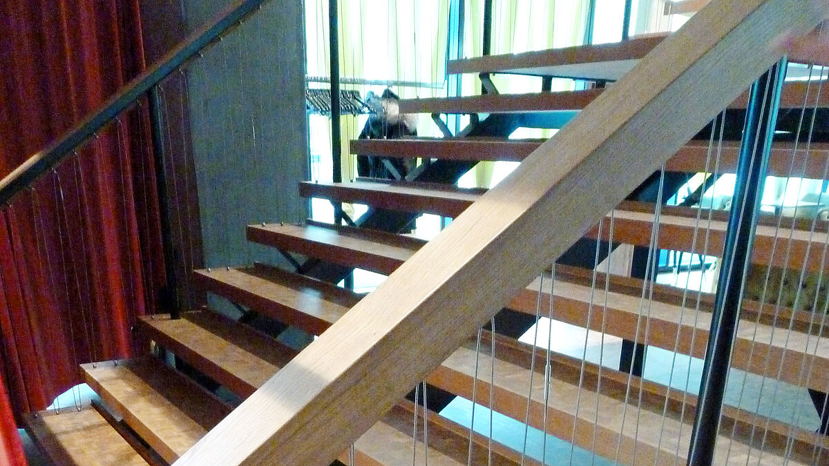 Das U-förmige Handlaufprofil ist ebenfalls mit Holz verkleidet.