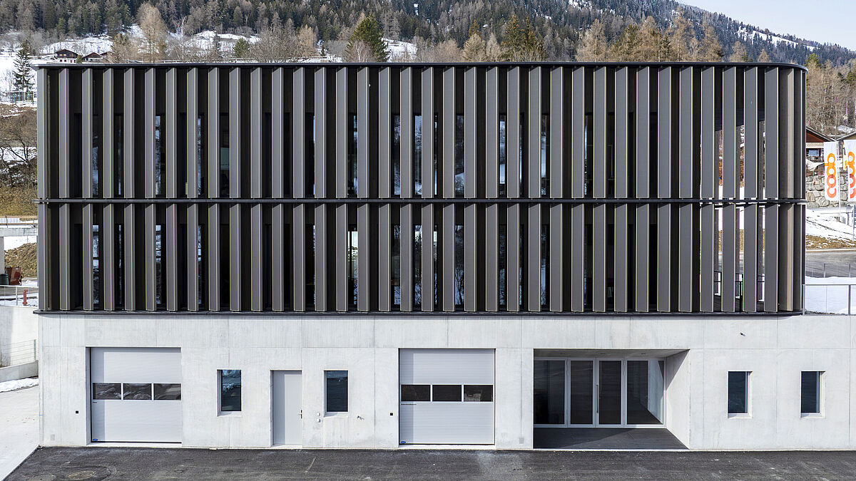 Vue de face : les lamelles verticales s’étendent sur deux étages. Trois profilés de lésènes se dessinent à l’horizontale.