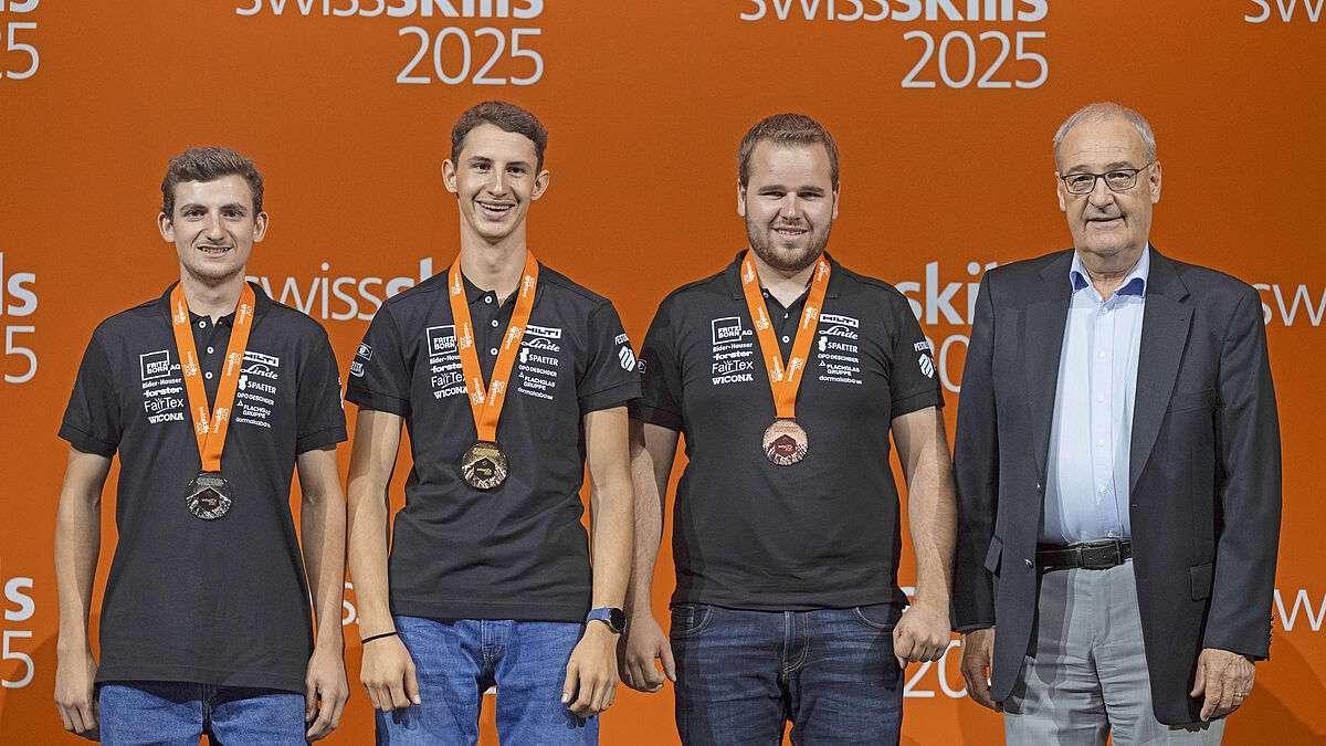 Podium des vainqueurs : Les trois brillants constructeurs métalliques lauréats avec le conseiller fédéral Guy Parmelin.