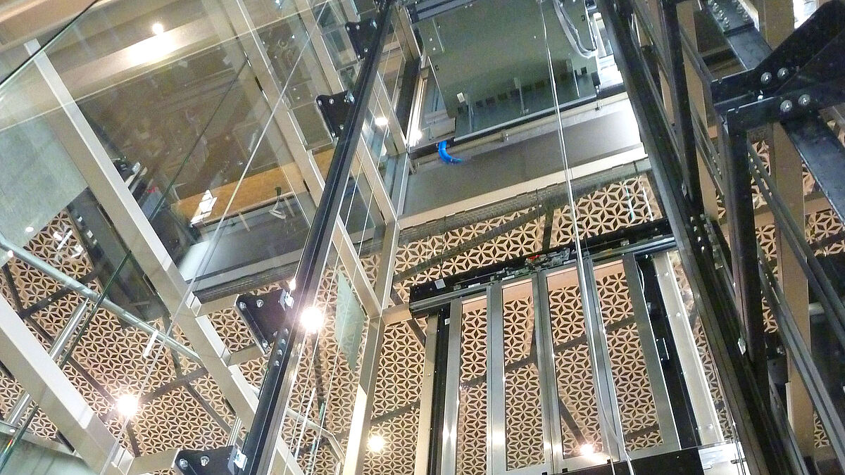 Transparence sur les deux étages commerciaux. Les tours d’ascenseur vitrées offrent une vue dégagée.