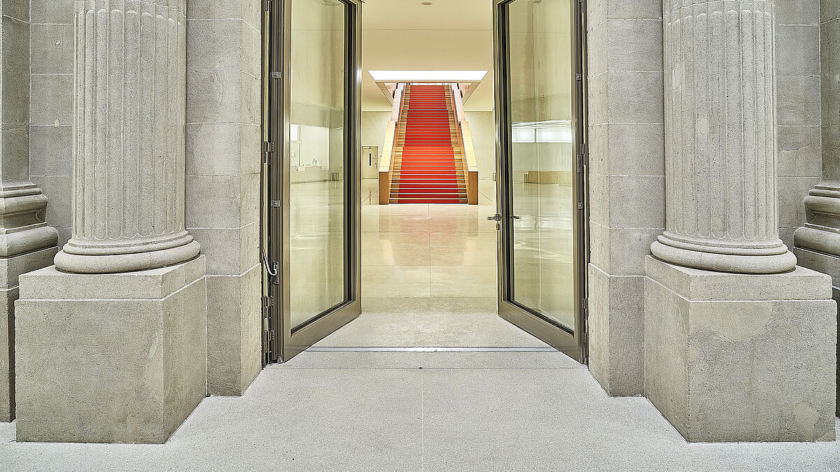 Die zweiflügelige, transparente Brandschutztüre in zeitgemässer Formensprache aus dem Stahlprofilsystem Janisol markiert den Übergang vom Altbau in den Neubau.