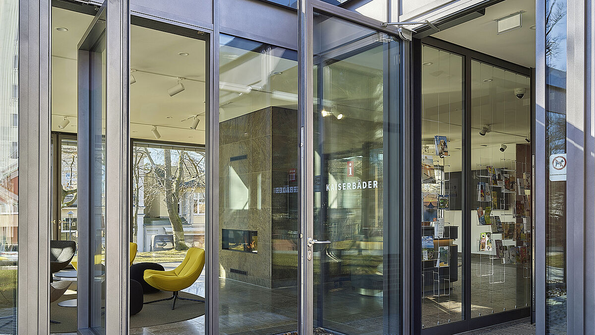 Deux entrées avec portes tournantes automatiques, placées à la jonction entre l’ancien bâtiment et l’extension, permettent de parvenir par un sas au pavillon lumineux abritant l’office de tourisme.