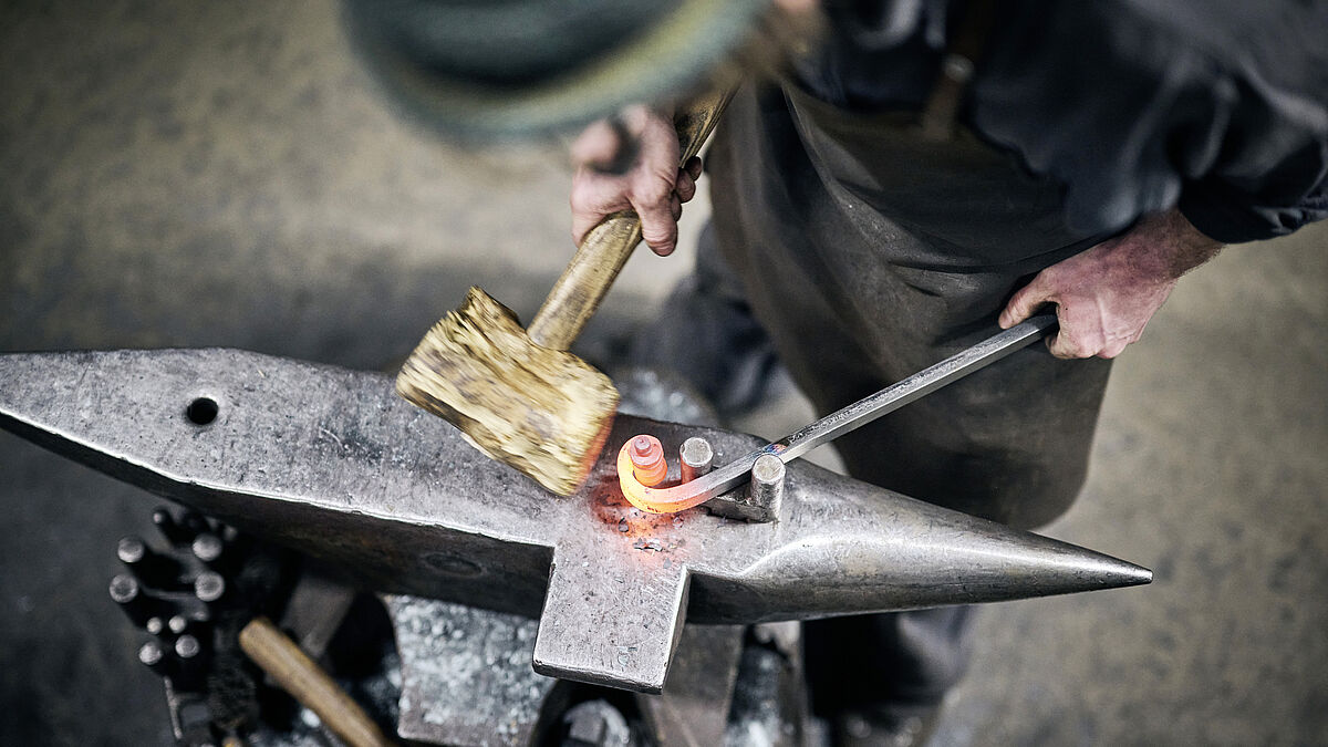 L’enroulement sur l’enclume à l’aide d’un maillet en bois. Le « Stöckli » en forme de fourche.