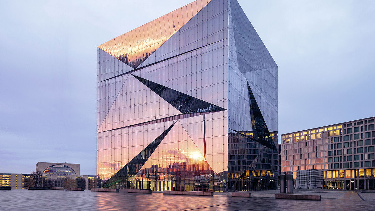 Die prismenförmigen Glasflächen spiegeln die Umgebung und lassen das Gebäude je nach Blickwinkel, Wetter und Tageszeit ständig anders aussehen.