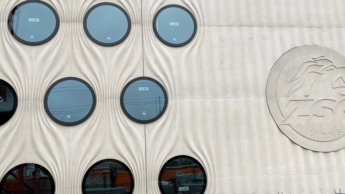 Côtés nord et sud, la structure filigranée en béton coulé sur place confère un drapé qui, tel un rideau replié, s’entrouvre autour des fenêtres circulaires. Photo : Surber-Metallbau AG