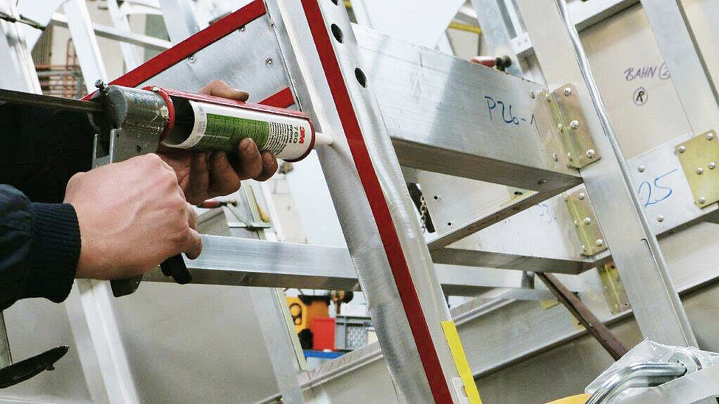 Vorbereitung Kombiklebung: Doppelseitiges Montageklebeband wird aufgeklebt und mit der Anpressrolle angedrückt. Die Klebe-Dichtmasse wird neben dem Klebeband aufgetragen. Bild IBZ. 