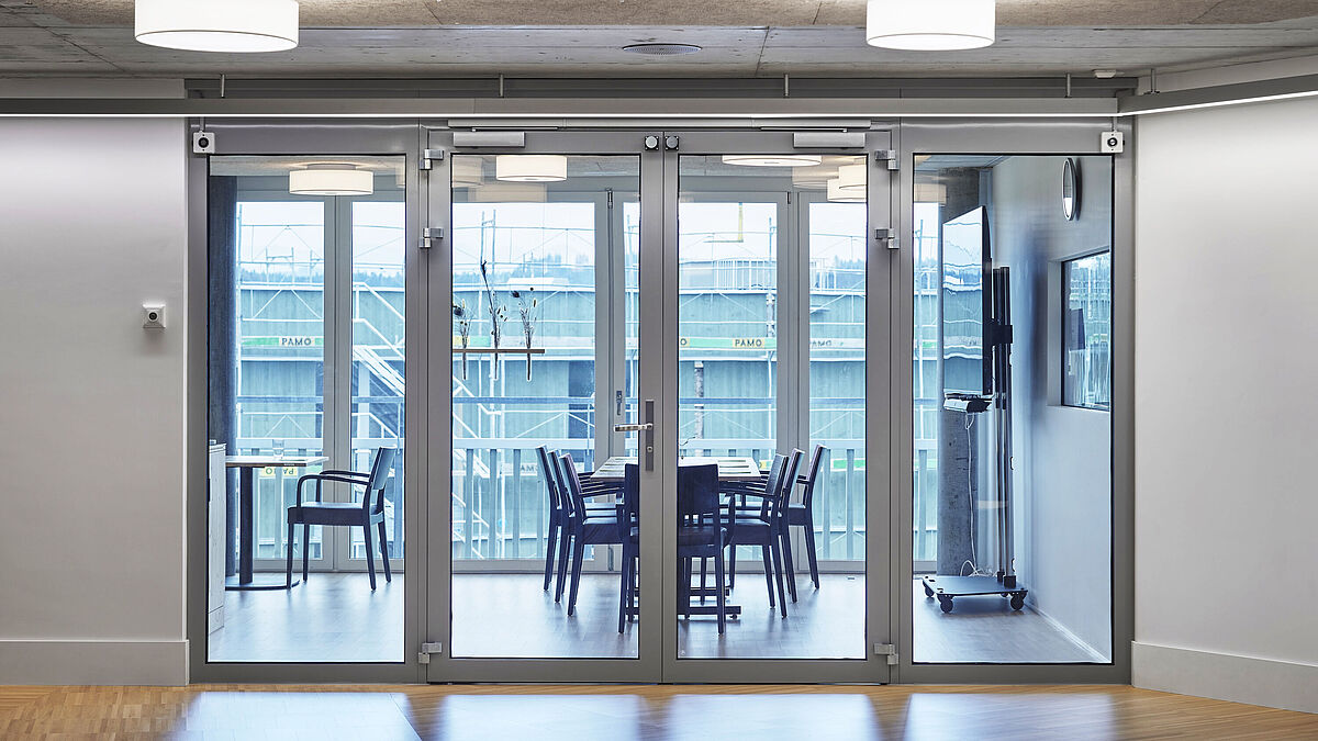 Helle Aufenthaltsbereiche mit grosszügigen Verglasungen und zweiflügeligen Brandschutztüren EI30 und EI60 aus dem System Forster Fuego Light schaffen eine harmonische Verbindung von Sicherheit und Transparenz. 