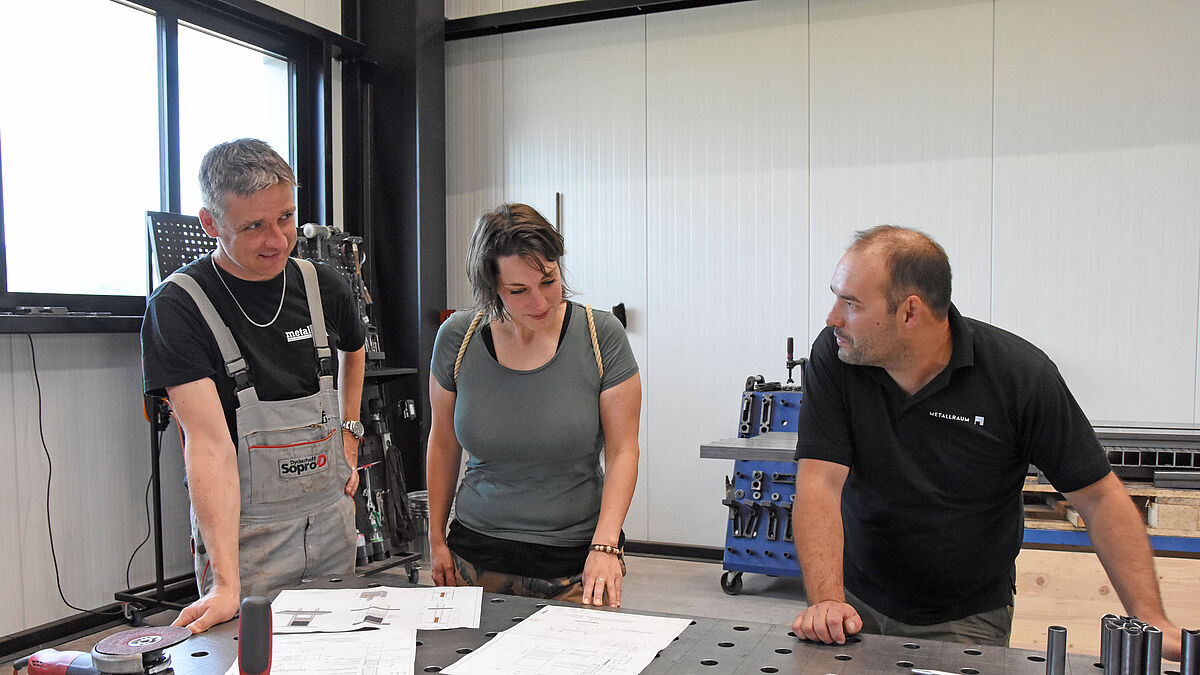 De gauche à droite : Michael Meuwly (enseignant et responsable du groupe spécialisé BBZ Zurich), Sandra Gerlach (coordinatrice du concept paysager de la vallée du Neckertal) et Matthias Zwyssig (responsable d’exploitation de Metallraum AG) discutent des plans d’exécution.