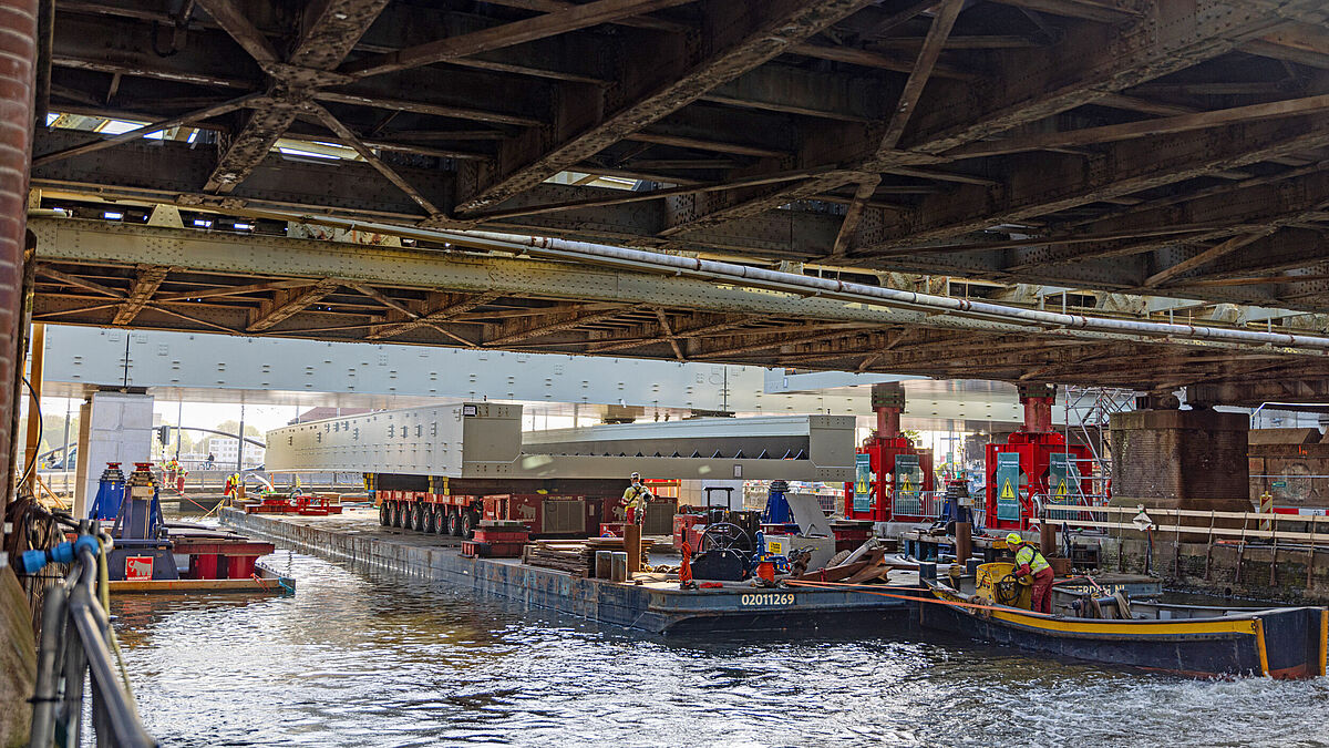 Das dritte Brückenteil wird unter der bestehenden Brücke hindurch an seinen Zielort gebracht.