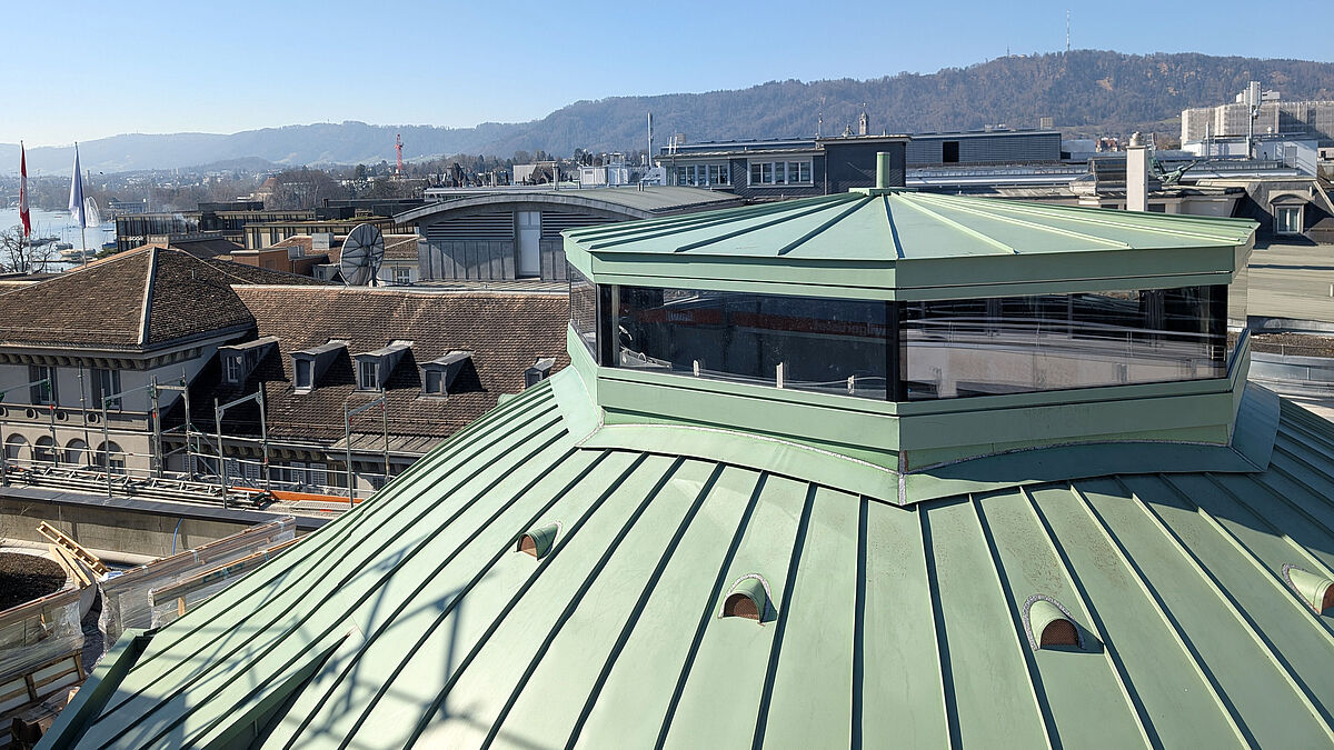 Posée au point le plus haut du bâtiment, la coupole octogonale présente des vantaux pliants s’ouvrant vers l’extérieur. 