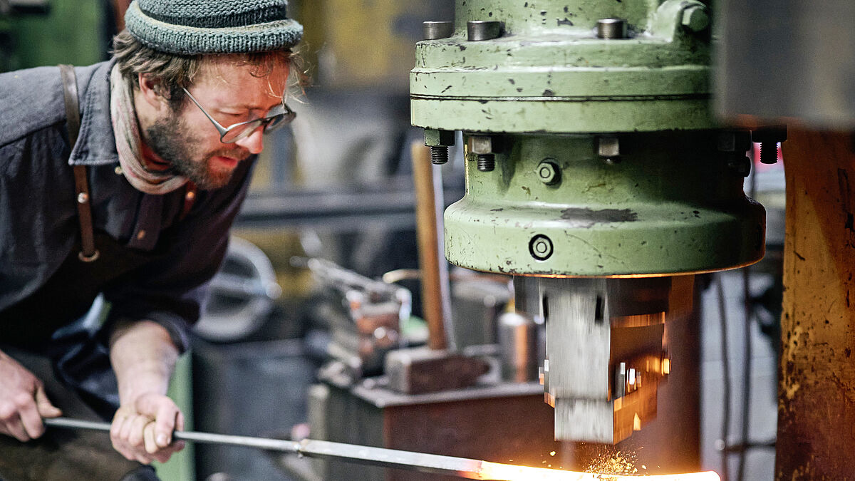Un collaborateur en train de forger. Le chauffage est assuré par induction.