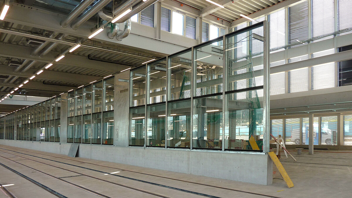 Glasfront Waschstrasse: Mit einer Länge von 51 m und einer Höhe ab Betonsockel von 4 m weist sie 34 Feldbreiten von 1,5 m auf und reflektiert hiermit den Raster der Aussenfassade. 