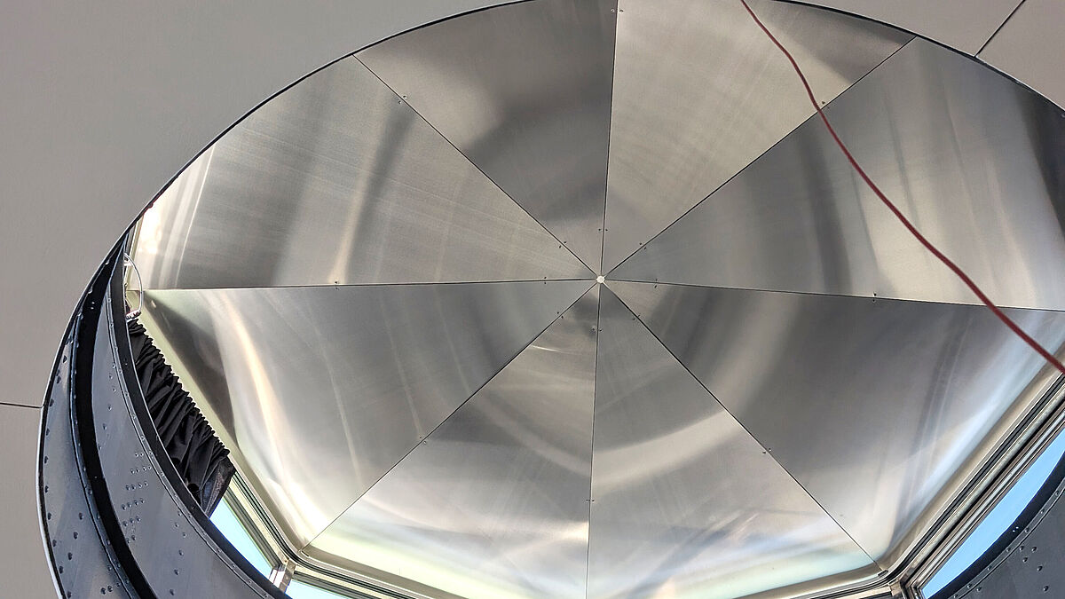 Sous-face de la coupole : les tôles d’habillage en acier inoxydable s’étendent sous forme de rayons depuis le centre. La structure porteuse classée monument historique avec ses tôles rivetées a été conservée. Photo : Surber Metallbau AG 