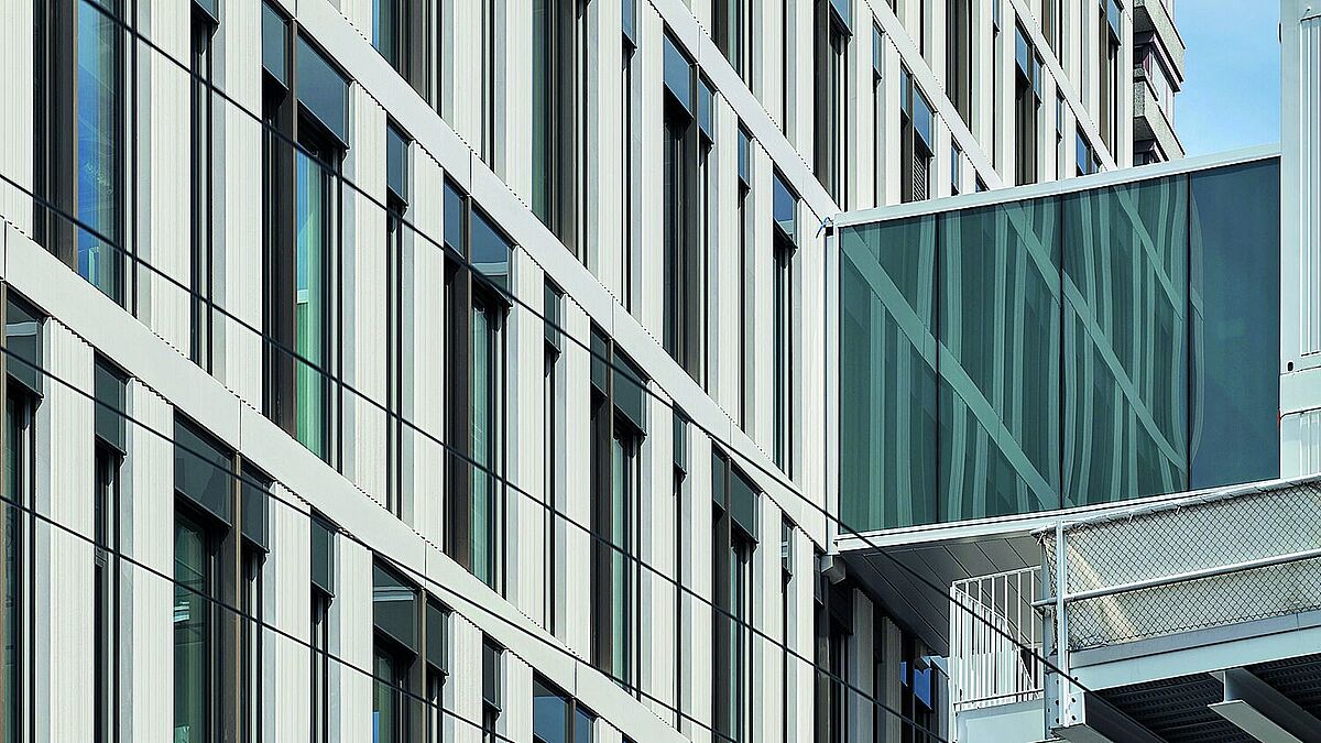 Die dunkel beschichteten Aluminiumprofile von Reynaers Aluminium bilden einen konturierenden Kontrast zur hellen Fassadengestaltung.