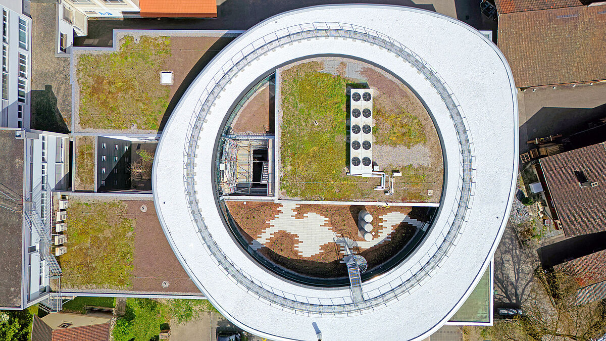 Die Aussenfassade bildet einen unregelmässig deformierten Kreis, der an mehreren Stellen leicht eingedrückt wirkt.  Bild: Bäumlin+John AG  Miró Messerli