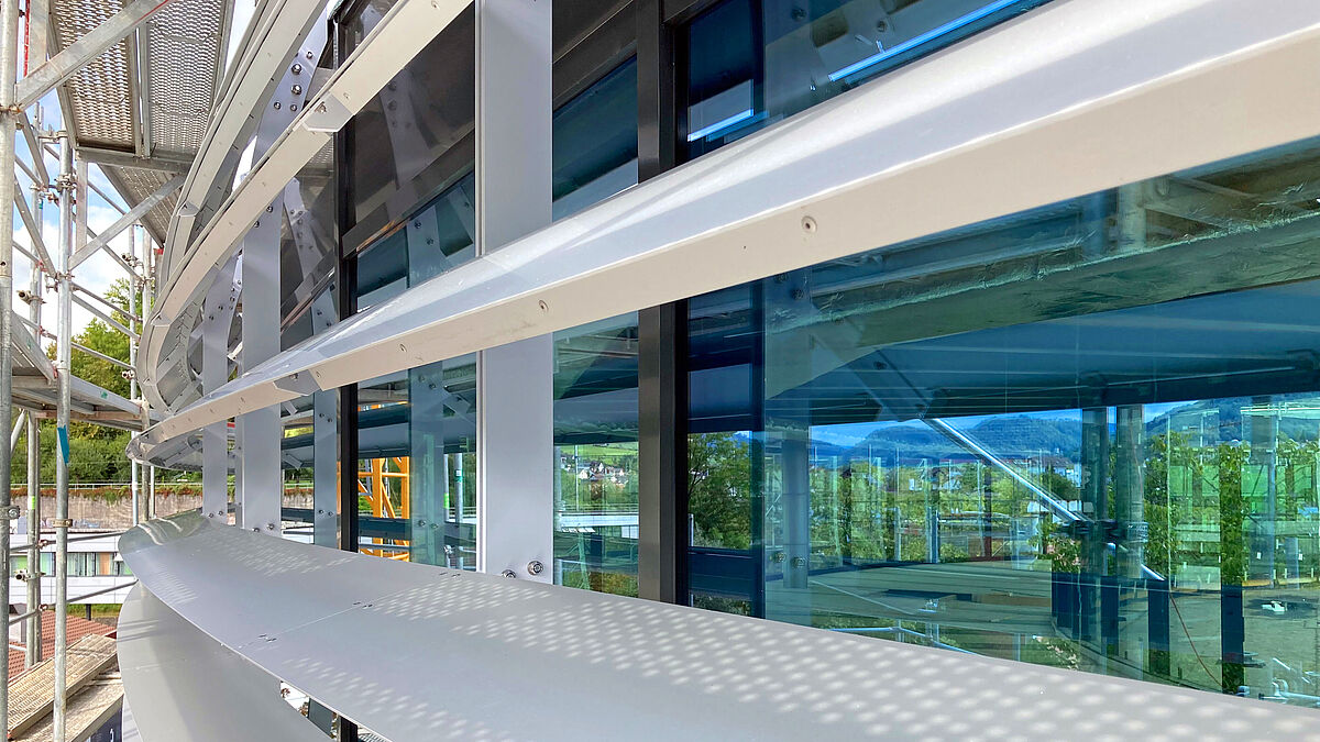 Aussenansicht während der Bauphase: Die Lamellen bestehen aus eloxiertem Aluminiumblech und sind unter Spannung an die örtlichen Konsolen befestigt.  Bild: Bäumlin+John AG  Miró Messerli