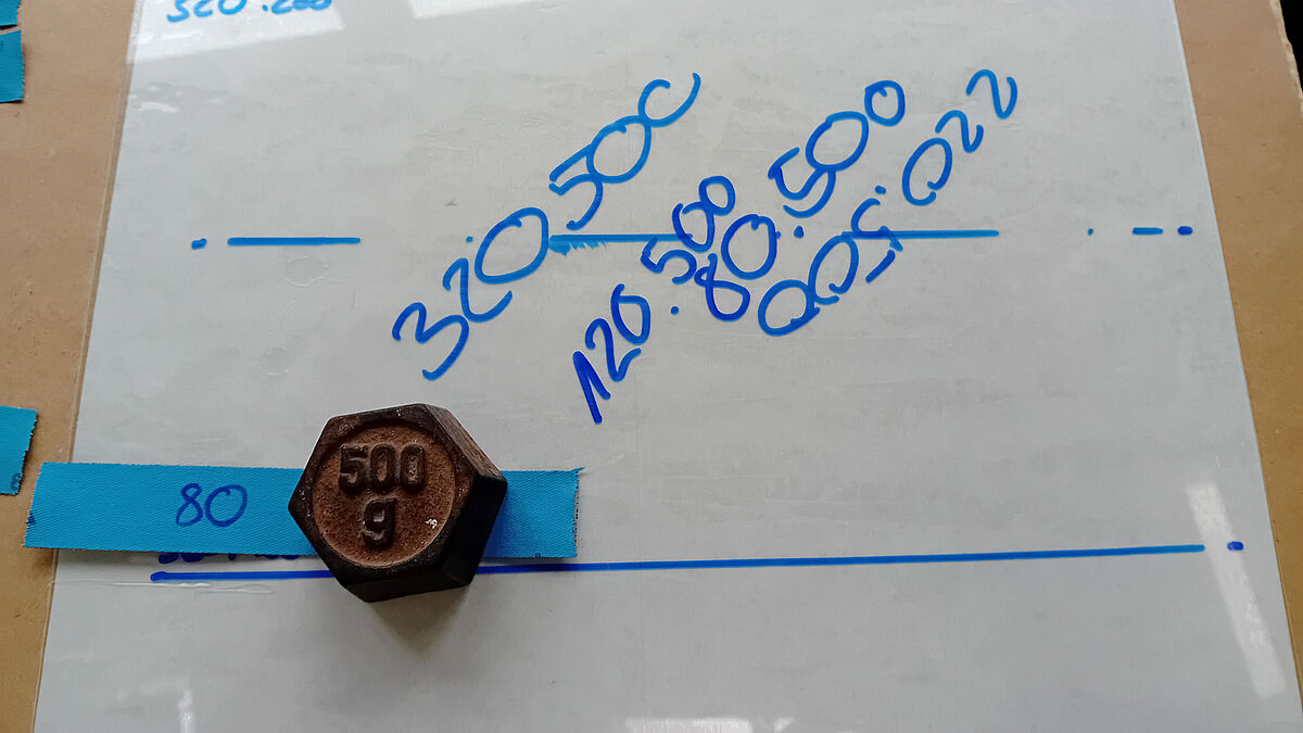 Endommagement de la surface avec du papier abrasif et un poids en fer.