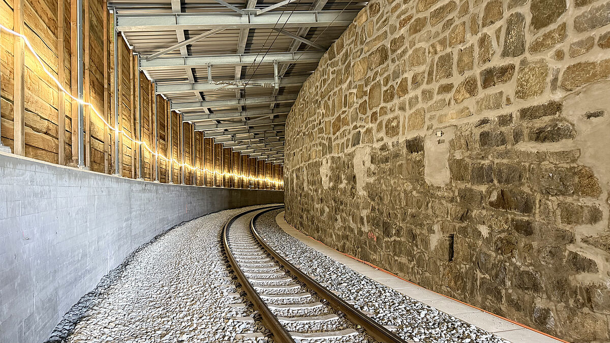 Innenansicht der fertiggestellten Schutzgalerie mit der Wandverkleidung aus Vollholzbohlen.