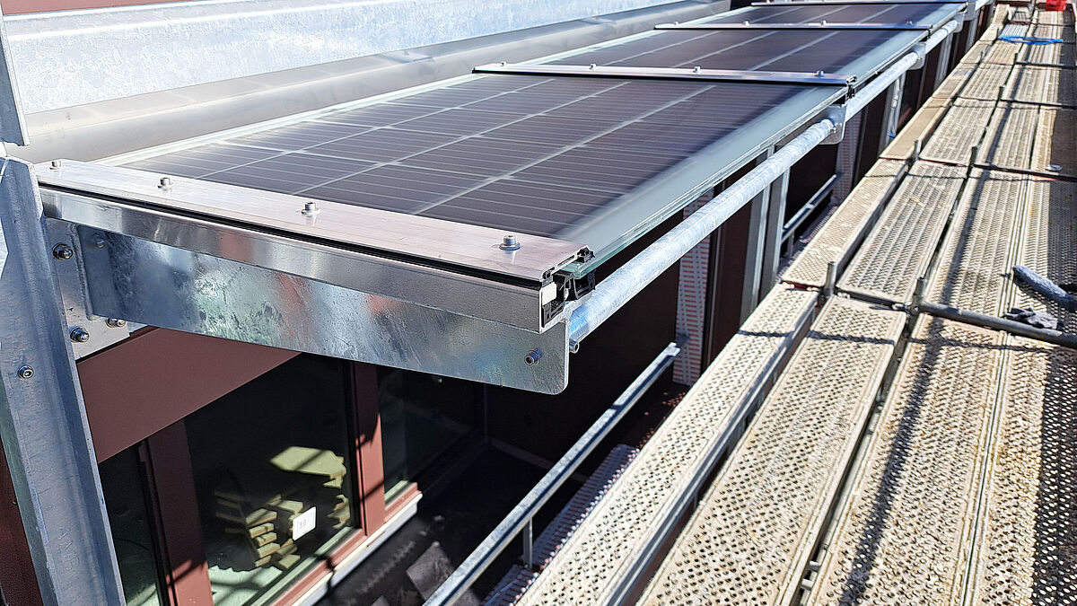 Sicht von oben: Die T-förmigen Kragarme mit Aufsatz-Gummiprofil und verschraubten Pressleisten eines Pfosten-Riegel-Systems. Die Klemmwirkung gibt den Solarmodulen einen sicheren Halt.