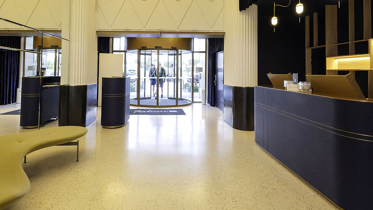 Der Blick aus der Lobby auf den Haupteingang zeigt, wie hochwertige und funktionale Türsysteme die stilvolle Eleganz des 4-Sterne-Hotels unterstreichen.