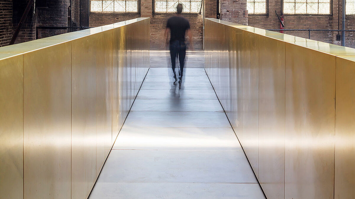 Eine blechbeplankte Passerelle erschliesst die Gebäudeteile in Querrichtung.