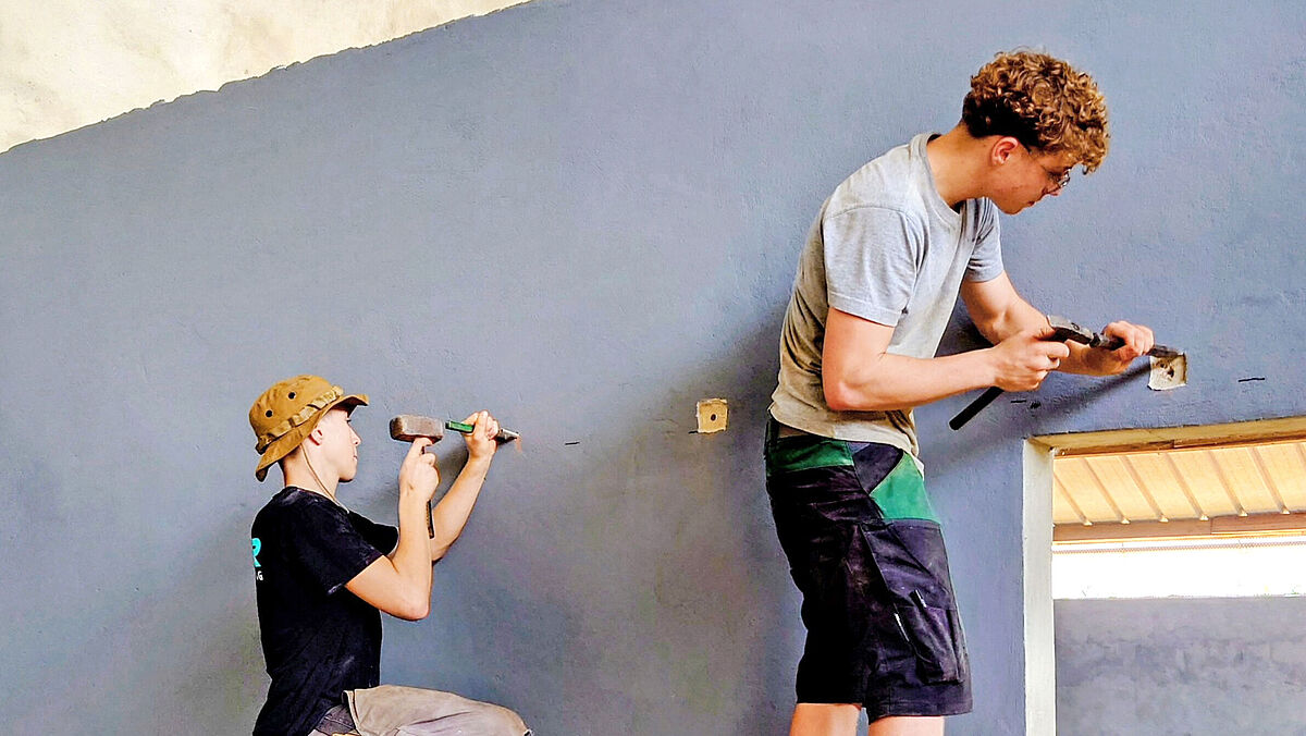 Les jeunes Suisses préparent le montage des rails de guidage.