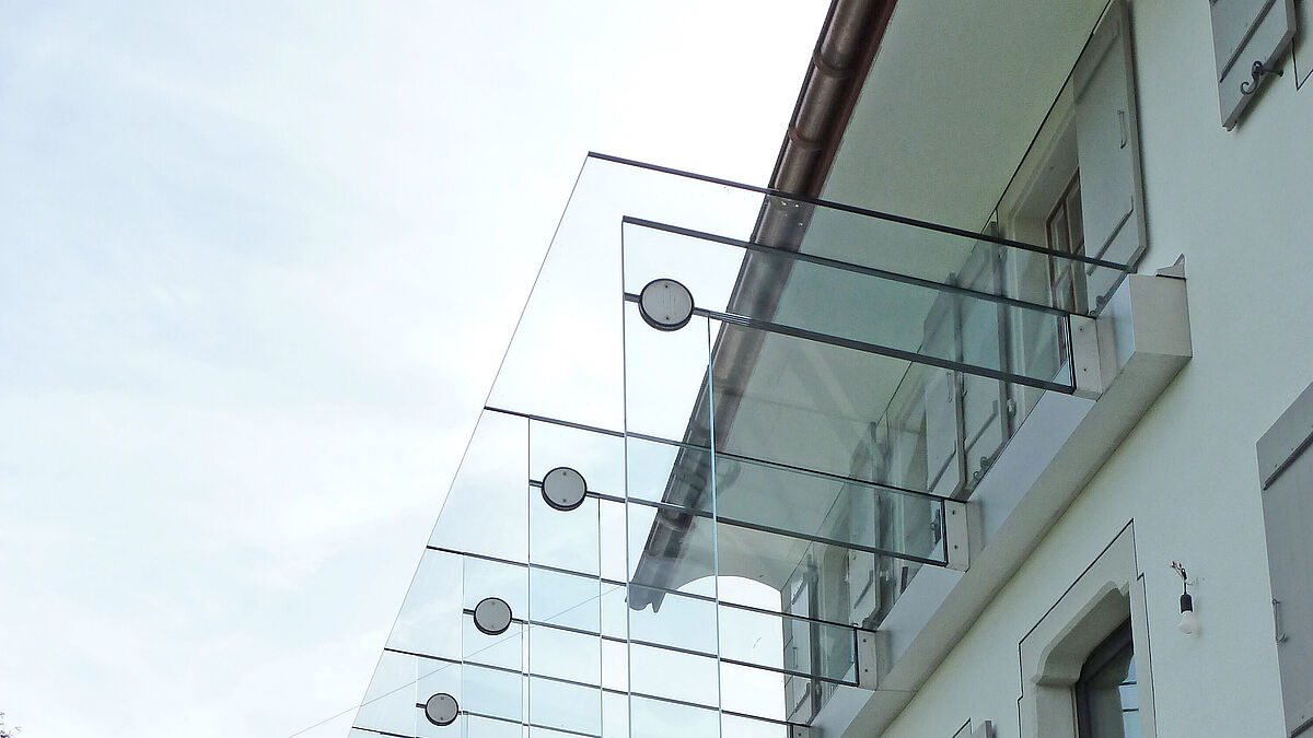 Bild: RedaktionSeitenteil über dem Eingang. Verspielte Wirkung der runden Edelstahl-Glasverbindungen am Himmel.