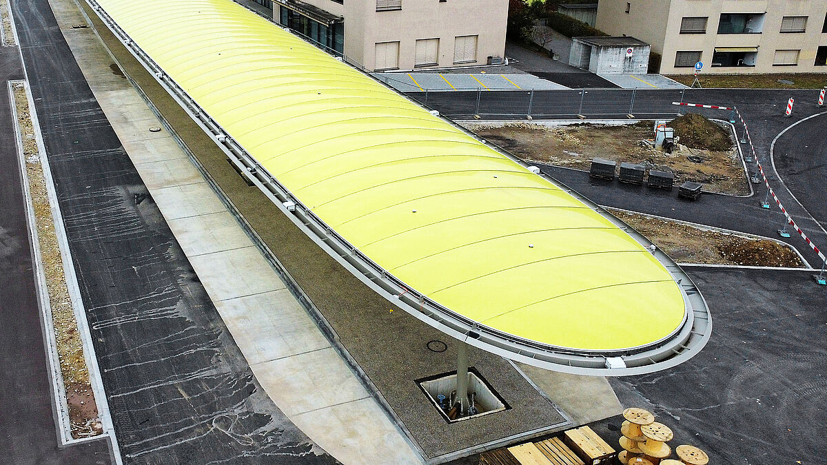 Bild: Suisseplan. Das Grosskissendach überspannt die Fläche zwischen den Randträgern ohne weitere Unterkonstruktion. Die Tragfähigkeit der Folie wird durch Edelstahlseile im Abstand von 1,50 m unterstützt.
