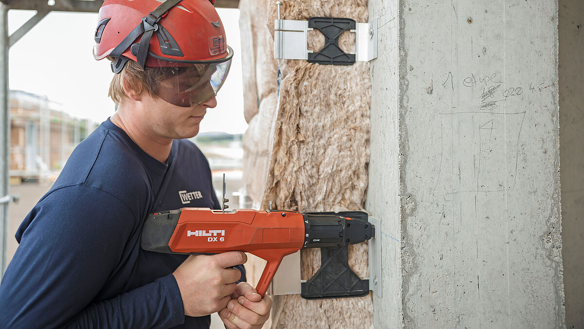 Montage der mit Glasfaser-Kunststoff thermisch getrennten Montagekonsolen MFT-FOX HT mit dem pulverbetriebenen Gerät DX 6 von Hilti.