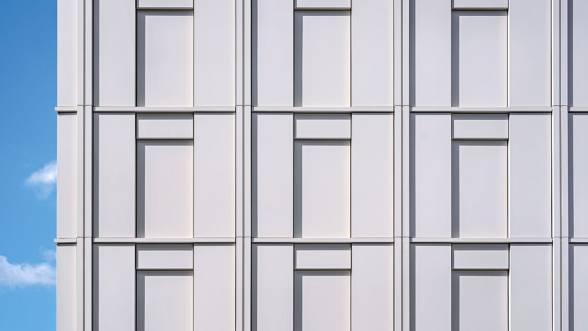 À l’extérieur, lésènes, corniches et garde-corps massifs structurent la façade.