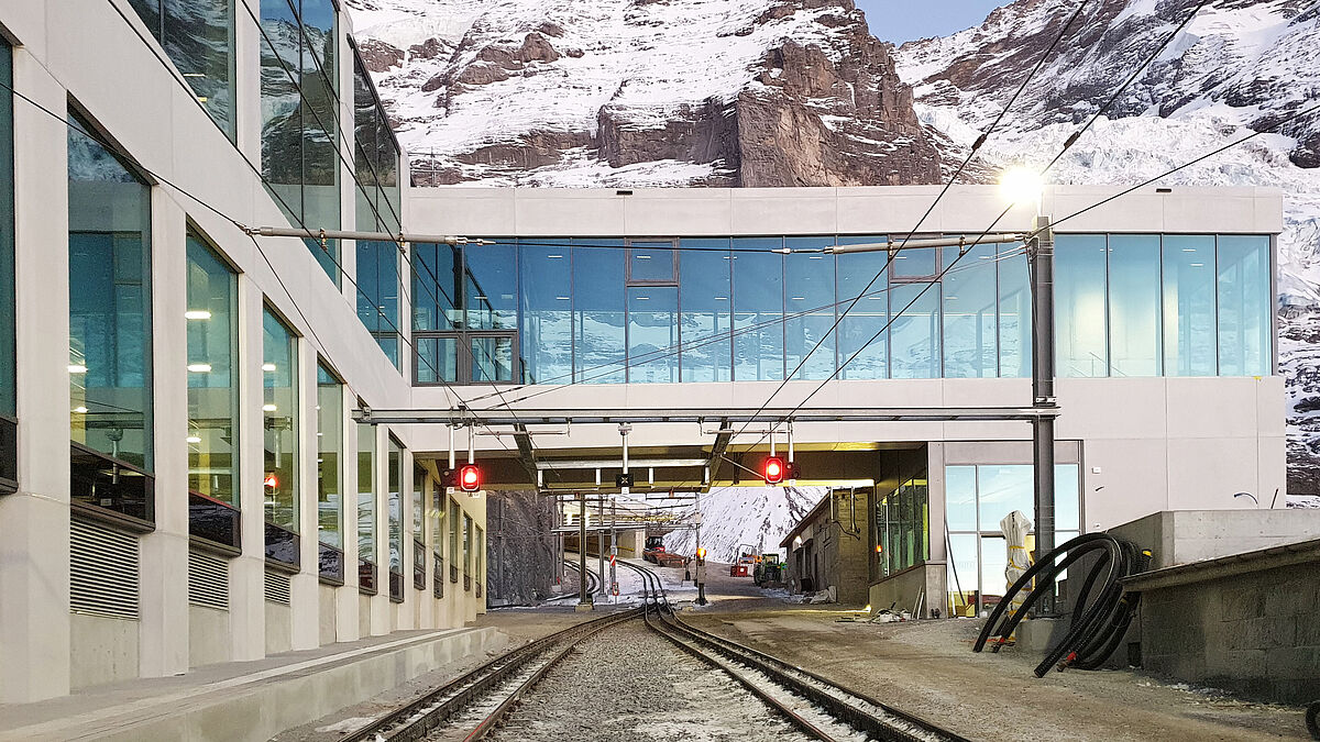 Les deux parallélépipèdes de verre créent le lien avec les bâtiments historiques de la gare de l’Eigergletscher, permettant d’accéder au train à crémaillère et offrant un accès direct aux pistes de ski.