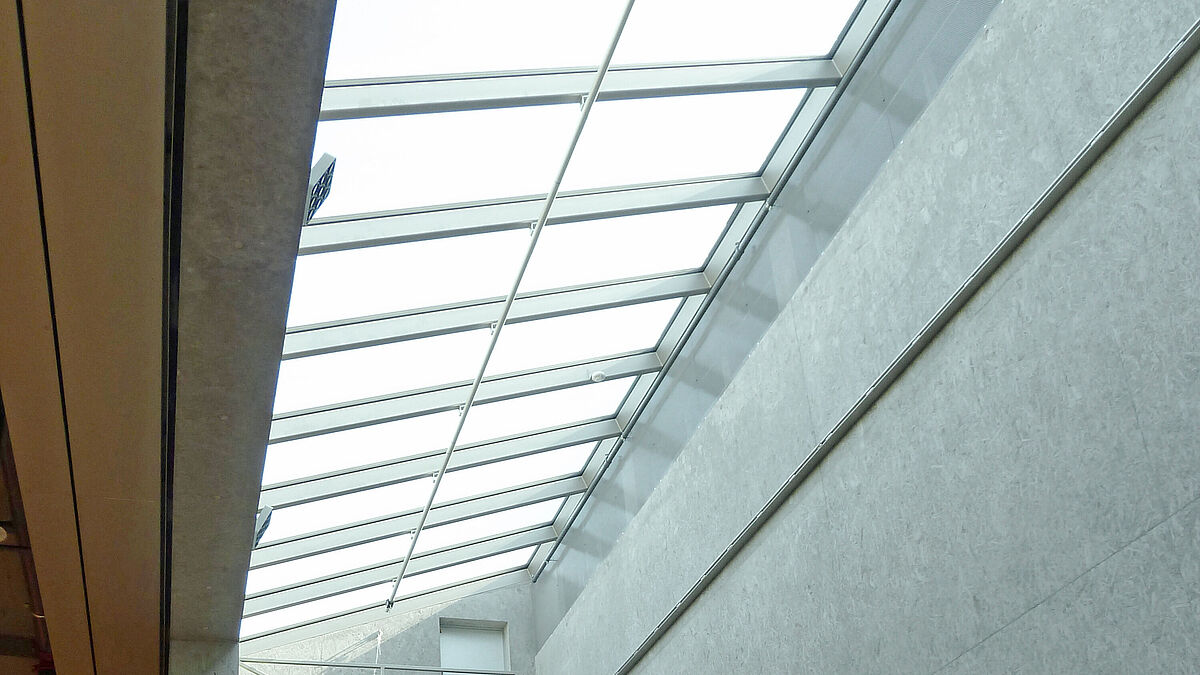 Das schlanke, langgezogene Glasdach kann mit einer auf Schienen fahrbaren Arbeitsbühne unterhalten werden.