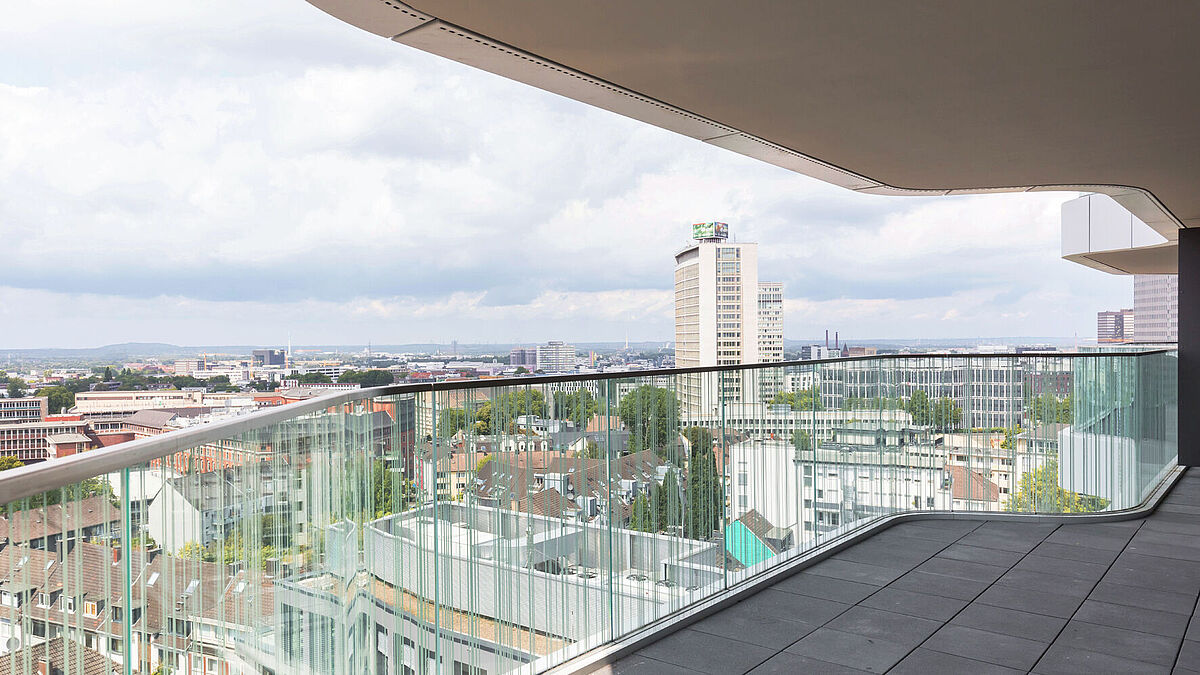 Le verre des balustrades des balcons est bombé, ce qui représente un défi pour de nombreux systèmes de fixation.