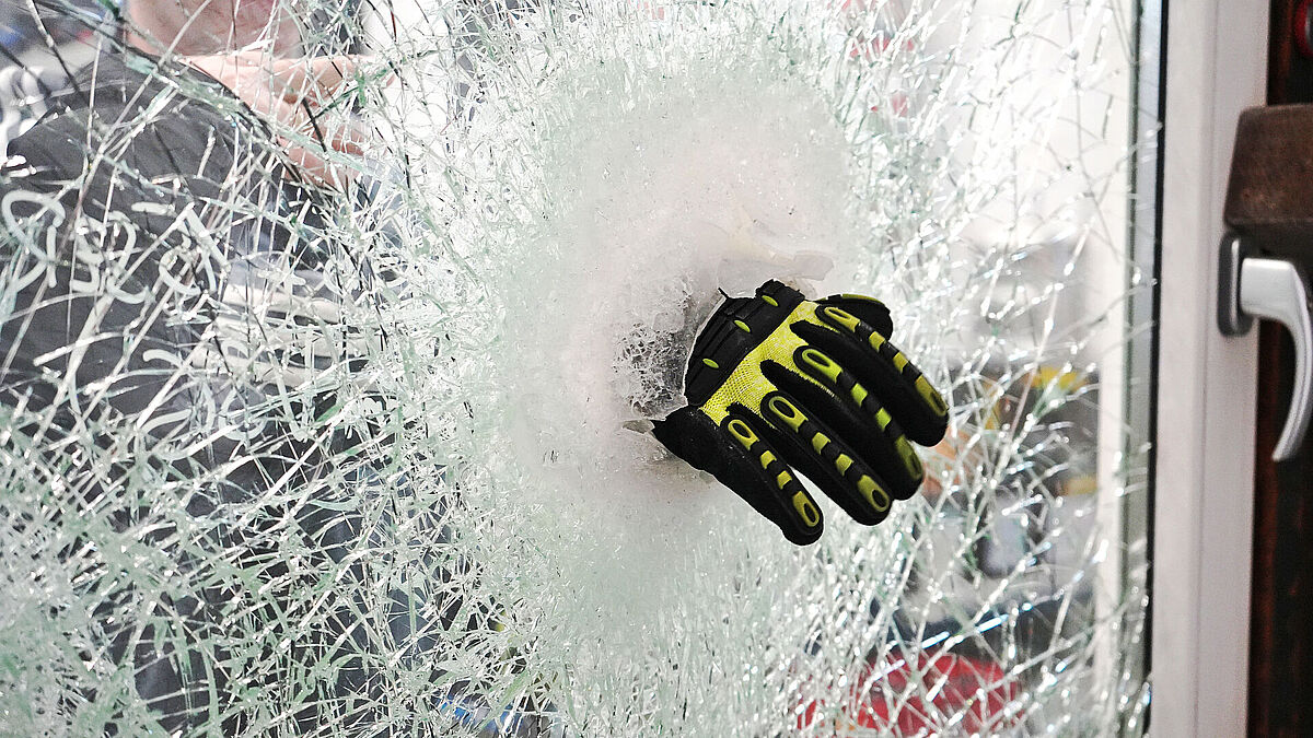 Im Bild wird die Zusatzanforderung «Liquid Save» gezeigt, bei der die Prüfer versuchen, eine durchgrifffähige Öffnung im Probekörper zu schaffen, die gross genug ist, um einen Molotowcocktail hindurchzustecken. 