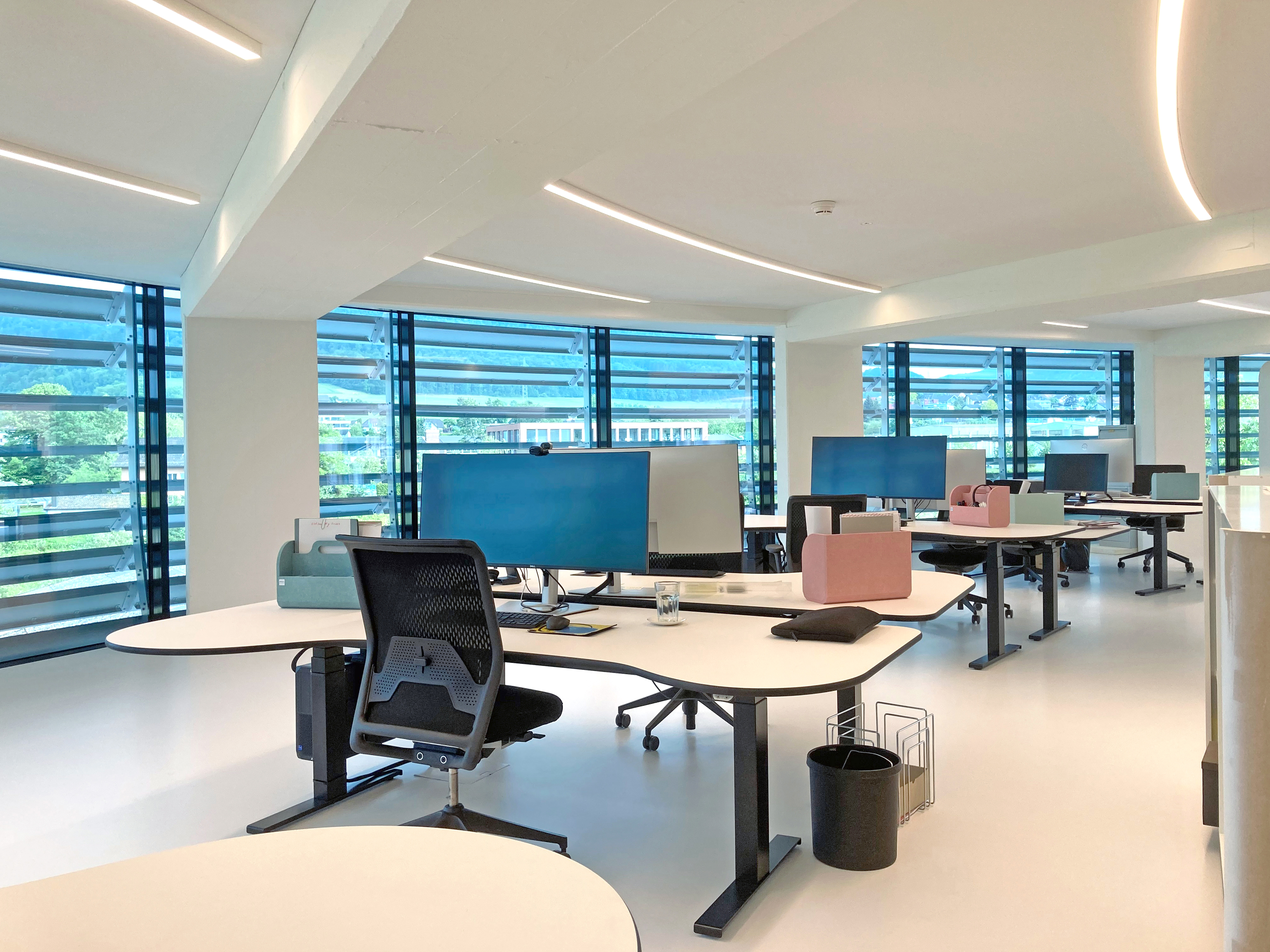Im äusseren Ring befinden sich 20 mobile und modern eingerichtete Doppelarbeitsplätze. Mit Tablets und flexibler Infrastruktur können sich Mitarbeitende überall im Büro einloggen.  Bild: Bäumlin+John AG  Miró Messerli