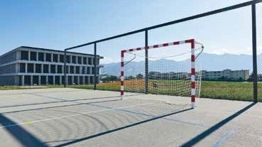 Auf dem Sportplatz der Sekundarschule in Riaz setzt der Ballfangzaun die spektakuläre Berglandschaft von Gruyère in Szene und tritt selbst unauffällig in den Hintergrund.